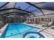 Beautiful screened pool and spa area with outdoor seating and lush landscaping for a serene outdoor experience at 1780 Pine Harrier Cir, Sarasota, FL 34231