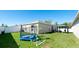 Well-maintained backyard with a trampoline, covered seating area, and lush green lawn at 2330 28Th E Ave, Palmetto, FL 34221