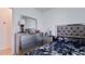 Bedroom with a mirrored dresser, lamp, a cushioned headboard, and patterned bedding at 2330 28Th E Ave, Palmetto, FL 34221