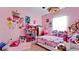 A pink bedroom with colorful decor, a window, a ceiling fan, and tiled flooring at 2330 28Th E Ave, Palmetto, FL 34221