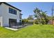 The backyard features a refreshing pool and spa enclosed by a safety fence, set against a backdrop of lush green grass at 2335 Oak Ter, Sarasota, FL 34231