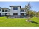 The expansive backyard features a secure pool and spa area, framed by a lush lawn and the home's modern architecture at 2335 Oak Ter, Sarasota, FL 34231