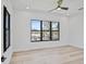 Bright, minimalist bedroom featuring hardwood floors, large windows, and modern ceiling fan at 2335 Oak Ter, Sarasota, FL 34231