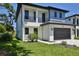 Modern two-story home with a driveway, dark garage door, and minimalistic landscaping at 2335 Oak Ter, Sarasota, FL 34231