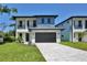Two-story home with modern design, featuring a large garage, driveway, and landscaped front yard at 2335 Oak Ter, Sarasota, FL 34231