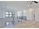 Bright hallway featuring light wood floors and modern black metal railings at 2335 Oak Ter, Sarasota, FL 34231