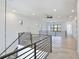Spacious hallway with black metal railings, recessed lighting, and light wood flooring at 2335 Oak Ter, Sarasota, FL 34231