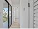 Bright hallway with hardwood floors and modern doors, leading to a balcony with views of mature trees at 2335 Oak Ter, Sarasota, FL 34231