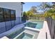 A refreshing pool and spa are fenced for safety, set against a backdrop of a modern home and lush landscaping at 2335 Oak Ter, Sarasota, FL 34231