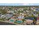 Aerial view of waterfront homes and tropical landscaping along a waterway and community at 2438 Baywood W Dr, Dunedin, FL 34698