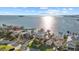 Aerial view of a waterfront home neighborhood with boat docks, a canal, and a view of the sea at 2438 Baywood W Dr, Dunedin, FL 34698