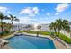 Backyard retreat features a large pool, spa, lush landscaping, a dock, and stunning views of the water at 2438 Baywood W Dr, Dunedin, FL 34698