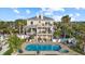 Resort-style backyard with a sparkling pool, lush landscaping, and outdoor dining area, perfect for entertaining at 2438 Baywood W Dr, Dunedin, FL 34698