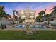 Resort-style backyard with a sparkling pool, lush landscaping, and outdoor dining area, perfect for entertaining at 2438 Baywood W Dr, Dunedin, FL 34698
