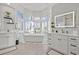 Bright bathroom featuring a standalone tub, marble accents, double vanity sinks, and natural lighting from multiple windows at 2438 Baywood W Dr, Dunedin, FL 34698