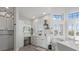 Well-lit bathroom featuring modern vanity, tiled accent wall, white cabinets, and a spacious tub area at 2438 Baywood W Dr, Dunedin, FL 34698
