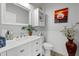 Bright bathroom featuring a white vanity, decorative mirror, storage shelves, and stylish décor at 2438 Baywood W Dr, Dunedin, FL 34698