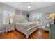 Bright bedroom with a wooden floor includes a neutral color palette, shutters, and a comfortable seating area at 2438 Baywood W Dr, Dunedin, FL 34698