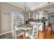 Charming dining area featuring a round glass table, stylish chandelier, lots of natural light, and breakfast bar in the kitchen at 2438 Baywood W Dr, Dunedin, FL 34698