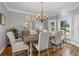 Elegant dining room with a chandelier, decorative mirrors, hardwood floors, and lots of natural light from large windows at 2438 Baywood W Dr, Dunedin, FL 34698
