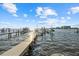 Waterfront view featuring a private wooden dock extending into clear waters; perfect for boating and enjoying coastal living at 2438 Baywood W Dr, Dunedin, FL 34698