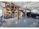 Spacious garage with epoxy floors, wooden support beams, storage, and room for a car and other vehicles at 2438 Baywood W Dr, Dunedin, FL 34698