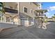 View of a three-car garage underneath balconies, offering ample parking and storage space with a gated outdoor area at 2438 Baywood W Dr, Dunedin, FL 34698