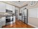 Modern kitchen featuring a stainless steel refrigerator, gas range, white cabinetry, and stylish backsplash at 2438 Baywood W Dr, Dunedin, FL 34698