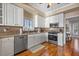 Bright kitchen with stainless steel appliances, including a gas range, and white cabinetry with ample storage space at 2438 Baywood W Dr, Dunedin, FL 34698