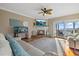 Bright living room boasts a fireplace, ceiling fan, tile floors, water view, and sliding doors for easy outdoor access at 2438 Baywood W Dr, Dunedin, FL 34698
