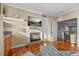Cozy living area showcases a white brick fireplace, built-in cabinets, and hardwood floors; a welcoming and bright ambiance at 2438 Baywood W Dr, Dunedin, FL 34698