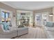 Comfortable living room featuring white leather seating, french doors, and a charming breakfast bar area with bright natural light at 2438 Baywood W Dr, Dunedin, FL 34698