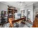 Office with hardwood floors, ceiling fan, custom bookcase, and access to the bathroom at 2438 Baywood W Dr, Dunedin, FL 34698