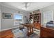 Bright office space with hardwood floors, ceiling fan, built-in bookcase, and water view at 2438 Baywood W Dr, Dunedin, FL 34698