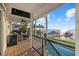 Relaxing covered outdoor deck with comfortable seating offers water views, access to the dock, and an outdoor TV at 2438 Baywood W Dr, Dunedin, FL 34698
