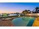 Backyard pool and spa by the water with brick pavers, lush landscaping and sunset views at 2438 Baywood W Dr, Dunedin, FL 34698