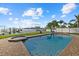 Backyard swimming pool and hot tub overlook a serene waterfront with clear skies and lush landscaping at 2438 Baywood W Dr, Dunedin, FL 34698