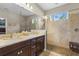 Bathroom featuring double sink vanity, large mirror and frameless shower with brown tiles and transom window at 2745 62Nd E Ave, Ellenton, FL 34222