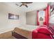 Cozy bedroom features a ceiling fan and natural light from the window with red curtains at 2745 62Nd E Ave, Ellenton, FL 34222
