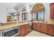 Modern kitchen featuring wooden cabinets, granite countertops, stainless steel appliances, and a breakfast bar at 2745 62Nd E Ave, Ellenton, FL 34222