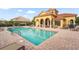 Community pool featuring a yellow clubhouse, surrounded by lounge chairs and a brick-paved deck at 2745 62Nd E Ave, Ellenton, FL 34222
