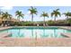 Community pool featuring palm trees, lounge chairs, and a view of the pond and fountain at 2745 62Nd E Ave, Ellenton, FL 34222