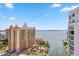 Expansive aerial view of beachfront condominiums, swimming pool and beautiful bay waters under a bright blue sky at 301 Quay Commons Dr # 1711, Sarasota, FL 34236