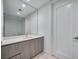 The sleek bathroom features modern vanity, large mirror, and glass enclosed shower at 301 Quay Commons Dr # 1711, Sarasota, FL 34236