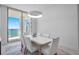 The dining room has a bright and airy feel due to the natural light and white-topped table set for six at 301 Quay Commons Dr # 1711, Sarasota, FL 34236