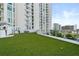 Expansive artificial turf dog run with glass fencing, perfect for pet exercise at 301 Quay Commons Dr # 1711, Sarasota, FL 34236