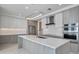 A modern kitchen with white and wood-tone cabinetry, stainless appliances, and an island at 301 Quay Commons Dr # 1711, Sarasota, FL 34236