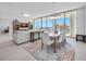 Open-concept living and dining area features a map-themed rug, modern furniture, and scenic views at 301 Quay Commons Dr # 1711, Sarasota, FL 34236