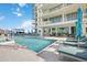 Resort-style community pool with modern lounge seating in front of a luxury condo building at 301 Quay Commons Dr # 1711, Sarasota, FL 34236