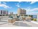 Rooftop patio with contemporary seating and a fire pit, perfect for entertaining with expansive city and ocean views at 301 Quay Commons Dr # 1711, Sarasota, FL 34236
